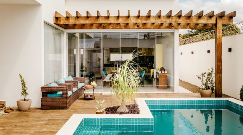 brown wooden table near swimming pool