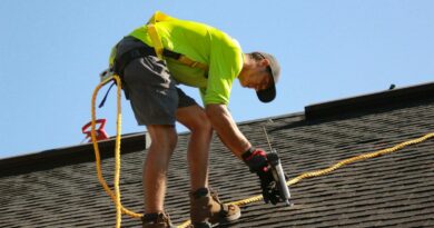 a man working on a roof with a power drill