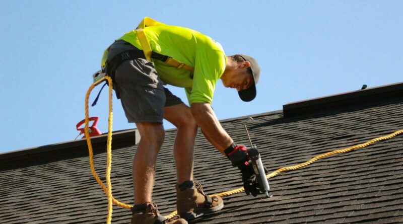 a man working on a roof with a power drill