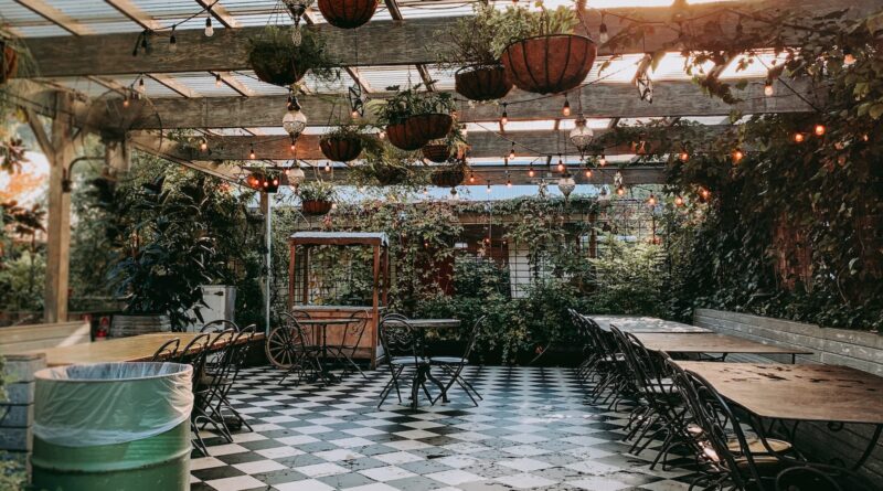 food cart near empty dining sets inside pergola during day