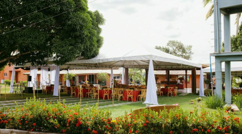 Outdoor event tent with tables and chairs on green grass